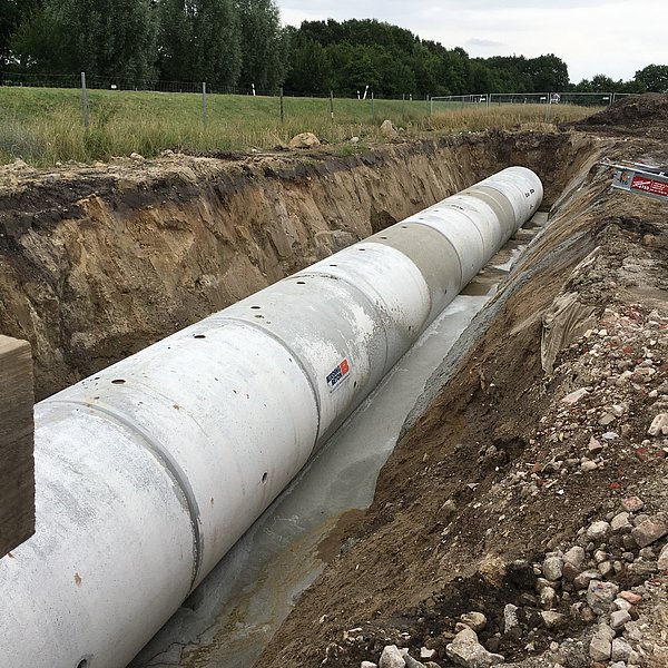Neu verlegtes Rohr im abgeböschten Rohrgraben