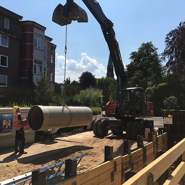 Herablassen eines Rohrelements mit dem Bagger